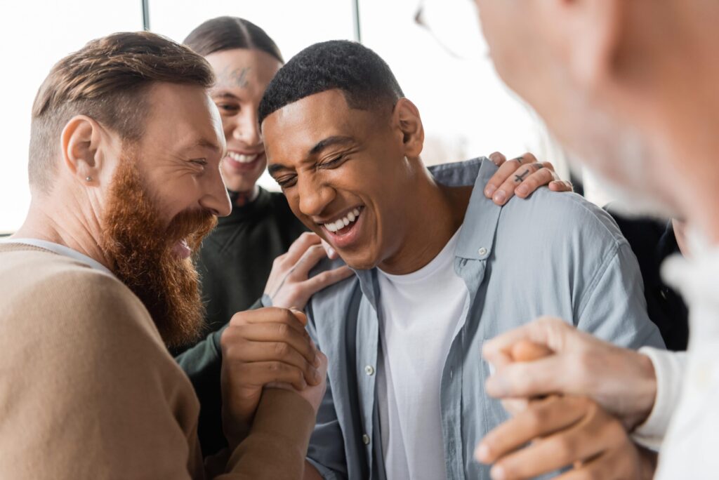 Group holding a smiling man, applauding him for his addiction recovery at My Time Recovery.