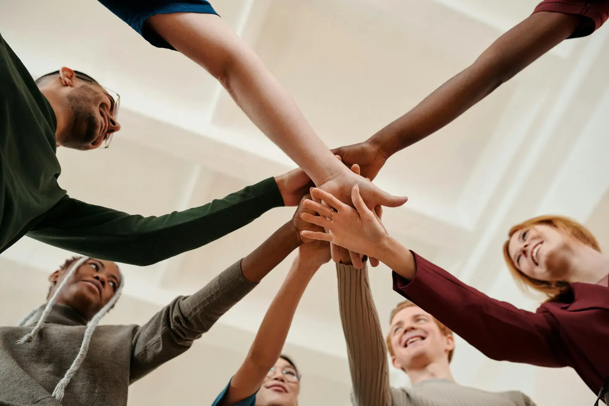 Close up of a group putting their hands together celebrating the progress they've made during coed rehab.