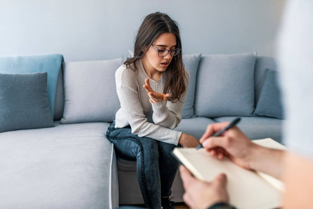 Close up of a patient opening up about her addiction struggles during a one on one therapy session at My Time Recovery.